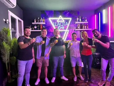 a group of people standing in a bar holding drinks at Llaqta Wasi in Lima