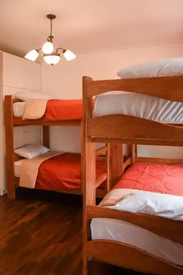 a dorm room with three bunk beds and a room with at Llaqta Wasi in Lima