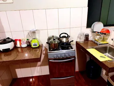 a kitchen with a stove with pots and pans on it at 200. Hermoso Departamento con Servicios Incluidos en Chorrillos in Lima