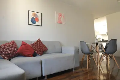 a living room with a couch and a glass table at Qurpawasi in Lima