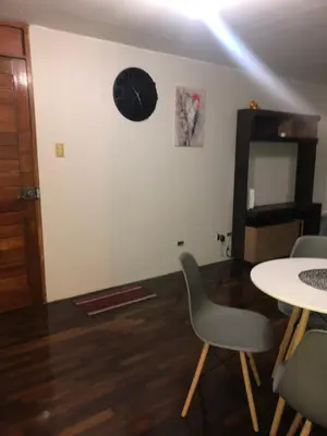 a room with a table and chairs and a clock on the wall at Qurpawasi in Lima