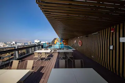 a balcony with tables and chairs on a building at Hilton Garden Inn Lima Miraflores in Lima