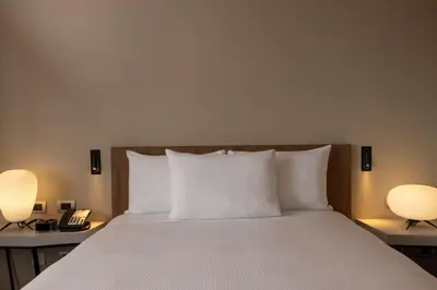 a bedroom with a bed with two lamps and a phone at Hilton Garden Inn Lima Miraflores in Lima