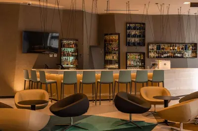 a bar in a restaurant with chairs and a counter at Hilton Garden Inn Lima Miraflores in Lima