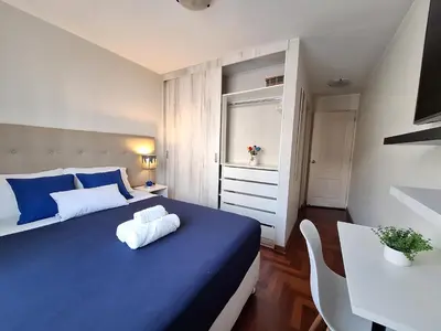 a bedroom with a blue bed and a table at Habitación Privada en departamento Compartido in Lima