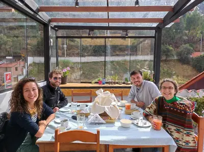 a group of people sitting around a table in a restaurant at Casa Agustina in Cusco
