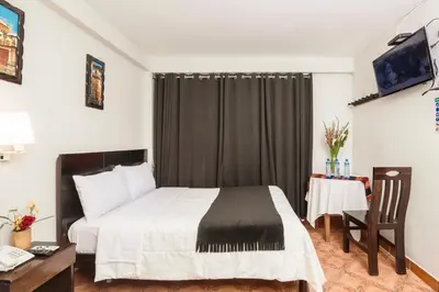 a hotel room with a bed and a table at KASAS DEL INKA MACHUPICCHU in Machu Picchu