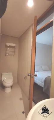 a small bathroom with a toilet and a bed at Elsa Wasi Cusco in Cusco