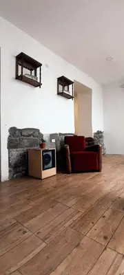 a living room with a red couch and a wooden floor at Elsa Wasi Cusco in Cusco