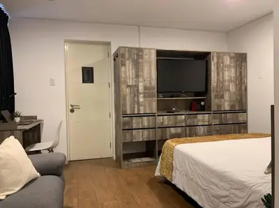 a bedroom with a bed and a flat screen tv at Suite en San Isidro-Frente al Supermercado Vivanda in Lima
