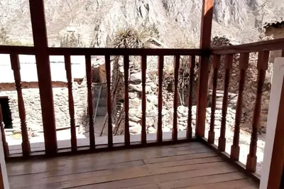a balcony with a view of a rock wall at APARMENT SAMANA HOUSE OLLANTAYTAMBO in Ollantaytambo
