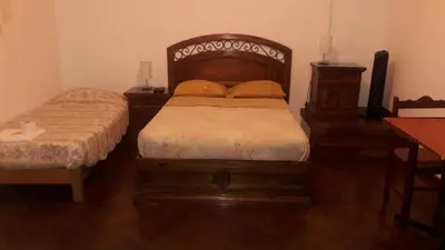 a bedroom with two beds and a wooden headboard at Hospedaje Schell in Lima