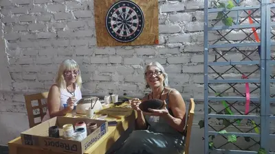 two women sitting at a table in a box at JUMANA in Nazca