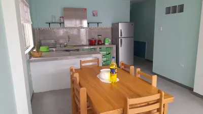 a kitchen with a wooden table with a bottle on it at IntiPunku in Cerro Azul