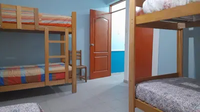 a room with three bunk beds and a door at IntiPunku in Cerro Azul