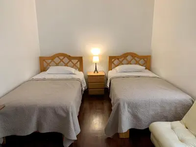 two beds in a room with a couch and a lamp at Miraflores Center - Larcomar, Parque Kennedy, Malecón in Lima