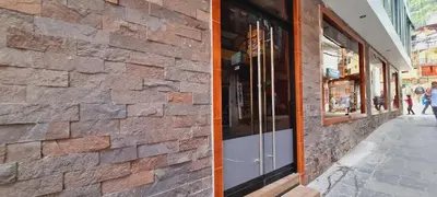 a brick building with a window on a street at Hotel Raices Machupicchu in Machu Picchu