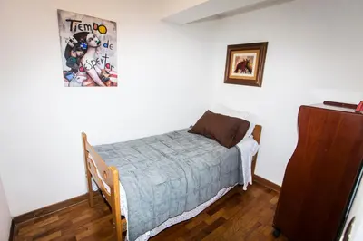 a small bedroom with a bed and a dresser at Beautiful Penthouse in Lima, in front of the park in Lima