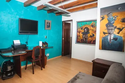 a room with a desk and a painting on the wall at Beautiful Penthouse in Lima, in front of the park in Lima