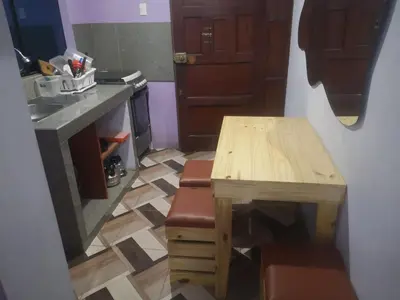 a small kitchen with a wooden table and a counter at Hostal Sol de Chosica in Chosica