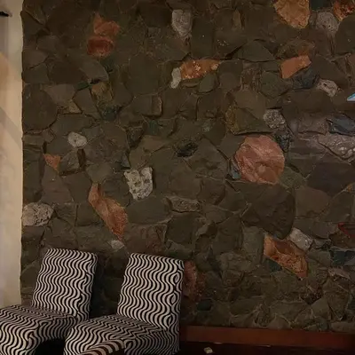 a stone wall with two zebra pillows in a room at Hosteria Suiza in Ica
