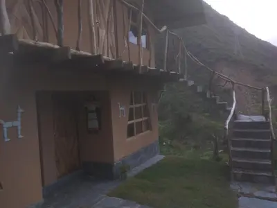 a house with stairs leading up to a mountain at Salkantay Hostel Chaullay in Santa Teresa