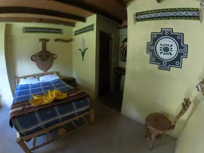 a bedroom with a bed in a room with a wall at Salkantay Hostel Chaullay in Santa Teresa
