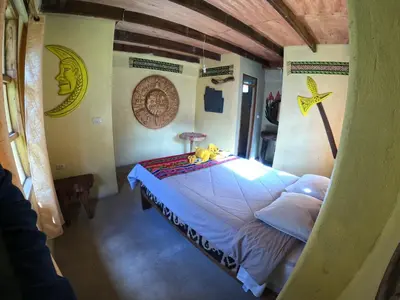 a bedroom with a bed with two stuffed animals on it at Salkantay Hostel Chaullay in Santa Teresa