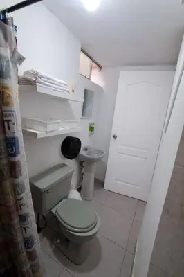a bathroom with a toilet and a sink at Hospedaje Kaihalulu in Punta Hermosa