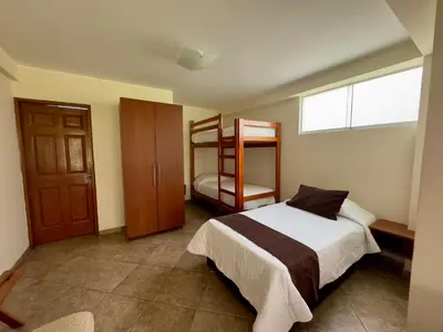 a bedroom with a bed and two bunk beds at Rio Lindo Ecolodge in Lunahuaná