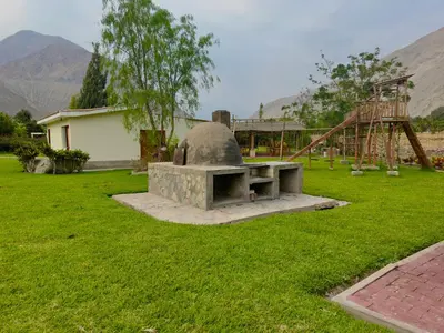 a stone bench in a yard with a playground at Rio Lindo Ecolodge in Lunahuaná