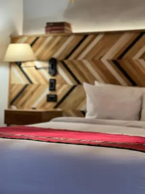 a bedroom with a bed with a wooden headboard at Casa Tunki in Cusco