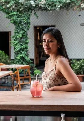 a woman sitting at a table with a drink at Casa Tunki in Cusco