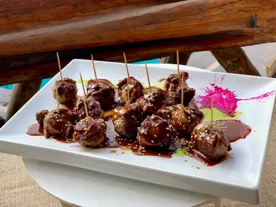 a plate of meatballs on toothpicks with sauce at Hotel Sol de Ica in Ica