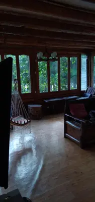 a living room with a hammock in a room with windows at La Casita de Oxapampa in Oxapampa