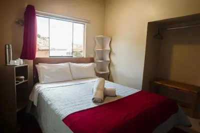 a bedroom with a bed with two towels on it at Cochito Cusco in Cusco