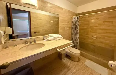 a bathroom with a sink and a toilet and a mirror at Loft Central Miraflores in Lima
