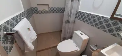 a small bathroom with a toilet and a sink at Hotel Garden House Huerta in Limatambo