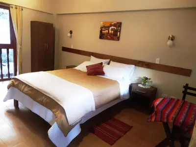 a bedroom with a large white bed in a room at Hotel Garden House Huerta in Limatambo