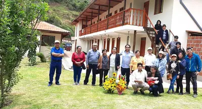 a group of people standing in front of a house at Hotel Garden House Huerta in Limatambo