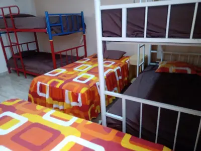 a room with two bunk beds and two chairs at Estancia Saraja in Ica
