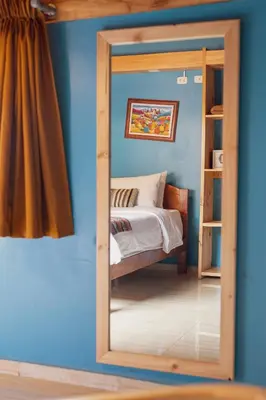 a mirror in front of a bedroom with a bed at Doña Catta Casa Boutique in Ollantaytambo