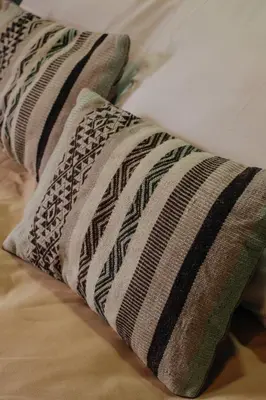 a pair of pillows sitting on top of a bed at Doña Catta Casa Boutique in Ollantaytambo
