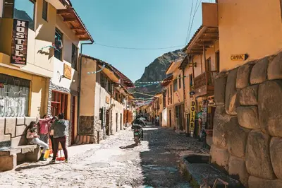 a group of people walking down a street with buildings at Doña Catta Casa Boutique in Ollantaytambo