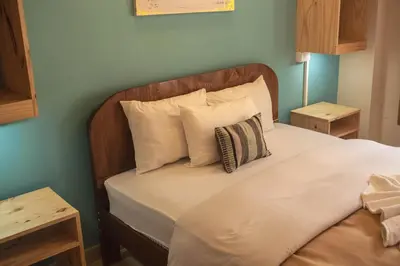 a bedroom with a bed with a wooden headboard and pillows at Doña Catta Casa Boutique in Ollantaytambo