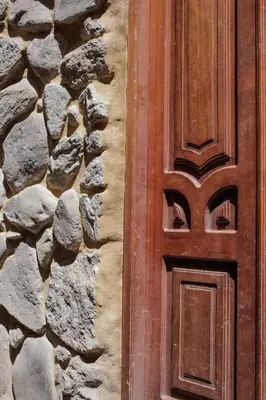 a wooden door on the side of a stone wall at Doña Catta Casa Boutique in Ollantaytambo