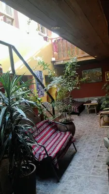 a patio with a bench and potted plants at B&B Chayana Wasi in Ollantaytambo
