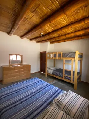 a bedroom with two bunk beds and a wooden ceiling at Las Cabañas de Incahuasi in Lunahuaná