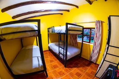 two bunk beds in a room with a yellow wall at Happy Land Valle Sagrado in Urubamba