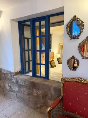 a room with a window and a red chair at CASA CRISTOBAL Siete Cuartones in Cusco